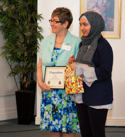 Maha Khan receiving Grade 7-9 Second Prize and plaque